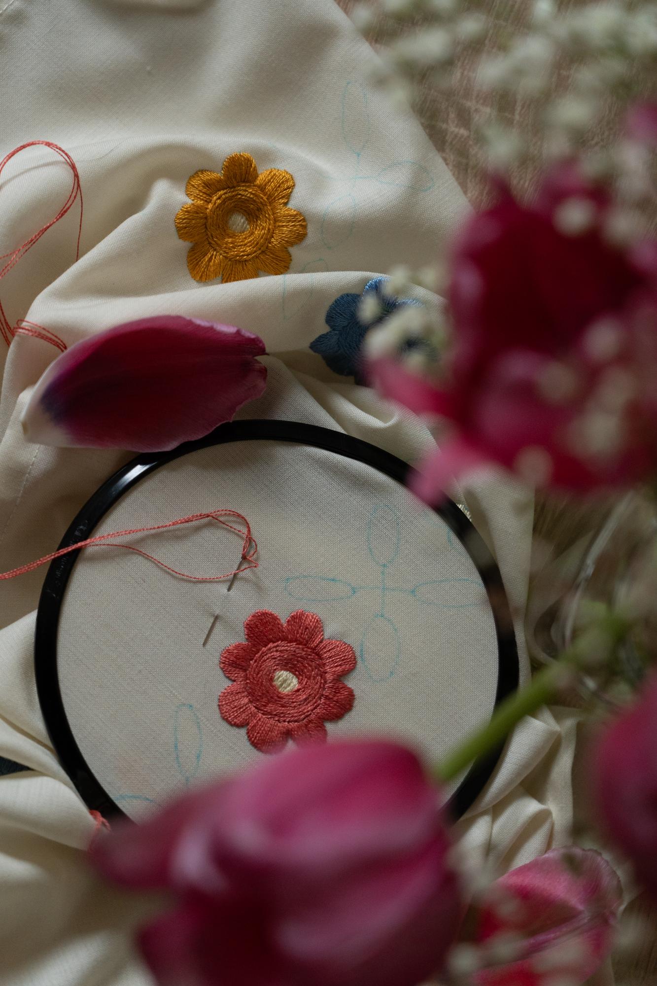 close-up of hand embroidery on linen with floral motif